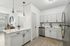 Bright and modern kitchen with sleek white cabinetry, stainless steel appliances, and elegant lighting, offering a stylish culinary space.