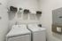 Modern laundry room with sleek washer and dryer, ample shelving, and organized storage solutions.