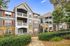 Community exterior with a modern facade, featuring spacious balconies, elegant red accents, and lush landscaping.