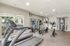 Bright and inviting fitness center with modern exercise equipment, featuring treadmills, bikes, and strength machines, surrounded by large windows for natural light.