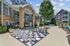 Outdoor area with a large chessboard, lush greenery, and a sparkling swimming pool, perfect for leisure and relaxation.