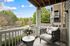 Charming balcony with a cozy armchair overlooking lush greenery, perfect for relaxing and enjoying nature.