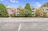 Charming apartment complex with classic architecture, surrounded by lush greenery and ample parking space.