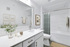 Bright, modern bathroom with sleek white countertop, elegant fixtures, and inviting tub surrounded by stylish decor.