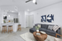 Modern and inviting living space featuring an open-concept kitchen with sleek bar stools, cozy sofa, and stylish decor.
