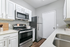 Bright, modern kitchen featuring stainless steel appliances, elegant white cabinetry, and a sleek countertop.