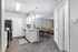 Contemporary open-plan kitchen with sleek cabinets, cozy dining area, and a spacious living room featuring elegant lighting.