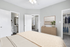 Inviting bedroom with ensuite bathroom, modern decor, and spacious walk-in closet, showcasing a serene and stylish living space.