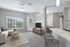 Bright and modern open-concept living space featuring a cozy living room with plush seating, sleek kitchen with a contemporary bar, and elegant dining area.