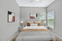 Bright and cozy bedroom with modern decor, large windows, and stylish art on the walls.