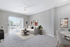 Bright and modern living room with plush carpet, elegant decor, and natural light streaming through sliding glass doors.