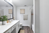 Chic bathroom with modern vanity, elegant mirror, and warm wood flooring for a stylish touch.