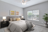Bright and inviting bedroom with plush bedding, elegant decor, and large window offering natural light.