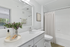 Elegant bathroom with modern fixtures, featuring a spacious countertop, large mirror, and vibrant decor adding freshness.