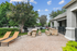 Inviting outdoor grill area with cozy lounge chairs, picnic tables, and lush greenery, perfect for relaxation and social gatherings.