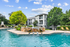 Inviting apartment community with lush landscaping and a refreshing pool, perfect for relaxing under the sun.