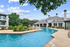 Inviting outdoor pool area with lush landscaping and elegant clubhouse, perfect for relaxation and gatherings.