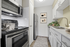 Modern kitchen with sleek stainless steel appliances, stylish white cabinetry, and elegant potted greenery.