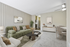 Chic living room with modern green sofa, stylish art, and cozy dining area next to a sleek kitchen.
