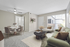 Chic and cozy living room with plush green sofa, modern dining set, and large window flooding the space with natural light.