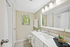Elegant bathroom with modern fixtures, large mirror, and stylish decor, featuring a bright and inviting ambiance.