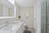 Elegant bathroom with modern fixtures, sleek white vanity, and calming gray tones accented by a stylish shower curtain.