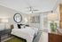 Elegant bedroom with modern decor, featuring a plush bed, stylish lamps, and a large decorative mirror.