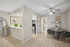 Bright modern apartment interior with open kitchen, stylish dining area, and sleek wood flooring.