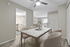 Elegant apartment dining area with a chic marble table, plush upholstered chairs, and open access to a modern kitchen and cozy living room.