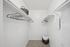 Spacious and modern walk-in closet featuring sleek shelving, a stylish wicker basket, and ample storage space.