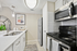 Modern kitchen with stainless steel appliances, bright white cabinetry, and stylish pendant lighting.