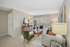 Bright and inviting living room with modern decor, featuring a cozy couch, stylish armchairs, large window with blinds, and elegant wood accents.