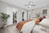 Inviting bedroom with modern decor, featuring a cozy bed, elegant ceiling fan, and spacious walk-in closets.