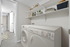 Modern laundry area with front-loading washer and organized shelving, offering convenience and style in a sleek apartment.