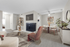 Modern open-concept living and dining area featuring a cozy fireplace, elegant furniture, and stylish decor, creating a warm and inviting atmosphere.