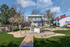 Inviting outdoor grill area with modern BBQ area, lush greenery, and playground, perfect for family gatherings.
