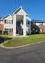 Charming apartment building with classic brick and siding exterior, featuring a welcoming entryway with stairs and well-maintained landscaping.