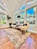 Bright and inviting reading nook with elegant armchairs and large windows showcasing a serene garden view.
