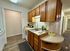 Charming kitchen with wooden cabinets, modern appliances, and cozy ambiance, featuring a convenient countertop with fresh fruit and herbs.
