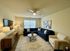 Inviting living room with a plush navy sectional, elegant armchair, and stylish decor, perfect for relaxation and entertainment.