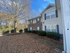 Charming two-story apartment with elegant brick facade and manicured landscaping under a clear blue sky, offering a serene and inviting atmosphere.