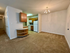 Inviting open-concept apartment kitchen with warm wooden cabinetry, modern appliances, and chic chandelier lighting.