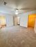 Spacious bedroom with plush carpeting, ceiling fan, and convenient walk-in closet access.