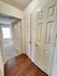 Inviting hallway with elegant wooden flooring, leading to a sunlit room with plush carpeting, in a modern apartment setting.