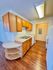 Charming kitchen with warm wood cabinets, sleek countertops, and integrated appliances in a cozy apartment setting.