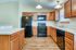 Modern kitchen with sleek black appliances, elegant wooden cabinetry, and crisp countertops set against a stylish design.