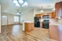 Inviting open-plan kitchen and living room with stylish wood flooring and modern appliances, perfect for entertaining.