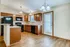 Bright, modern kitchen featuring elegant wood cabinetry, sleek black appliances, and stylish pendant lighting, perfect for a culinary enthusiast.