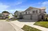 Charming suburban townhouses with inviting driveways and modern architectural design under a clear blue sky.