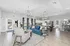 Inviting open-concept living space with modern furnishings, featuring a chic blue sofa, elegant lighting, and a spacious kitchen perfect for entertaining.